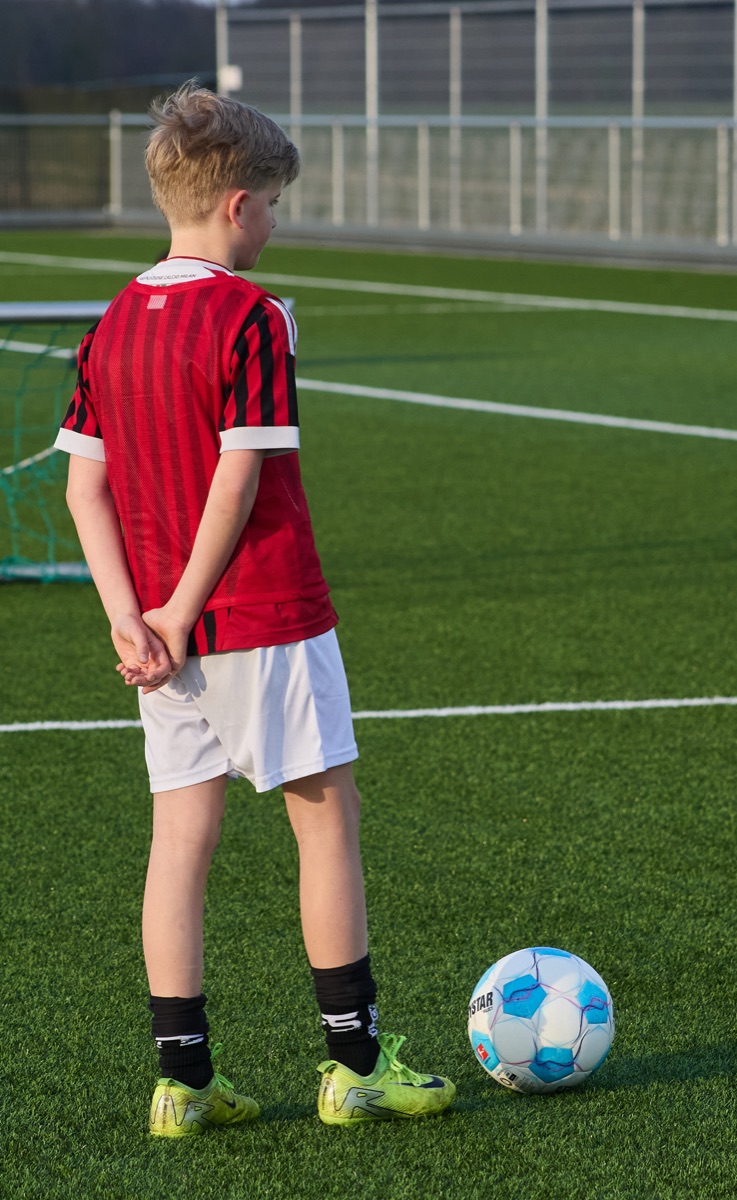 Jonge speler met bal op het trainingsveld
